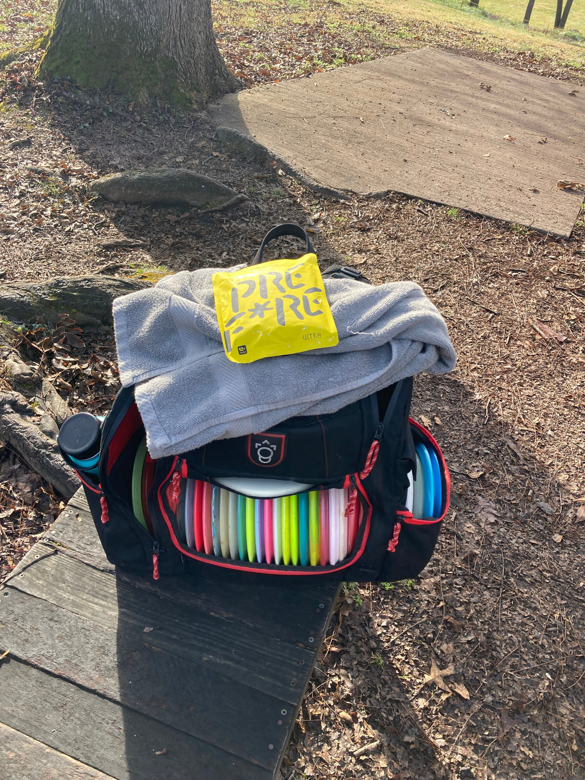 Disc golf bag with a yellow PREFIRE pouch on top