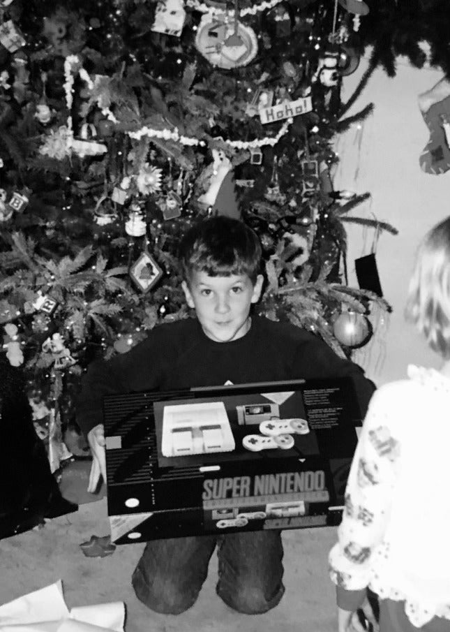 Kneeling by the Christmas tree with a new Super Nintendo