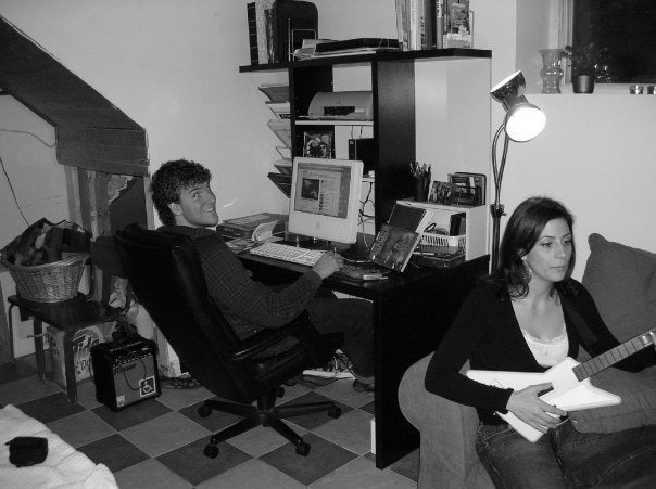 A desk under the stairs with an iMac, a friend playing guitar on the couch
