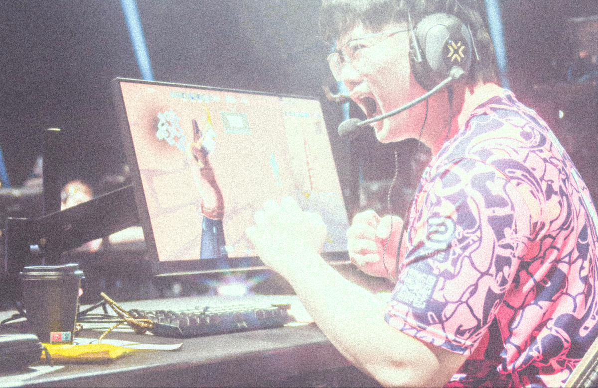 An esports player celebrating at his desk on stage